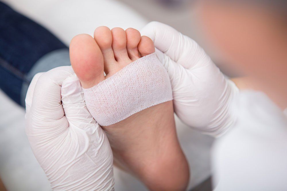 Podiatrist Placing Bandage On Foot — Podiatry In Forster, NSW