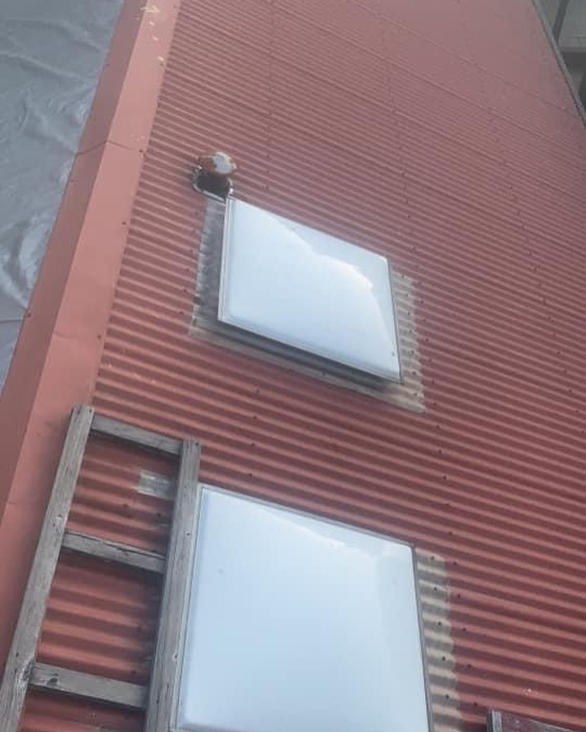 There are two skylights on the side of a building.