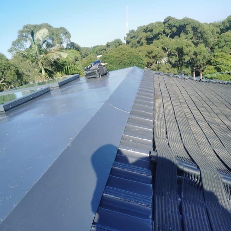 A shadow of a person is cast on the roof of a building
