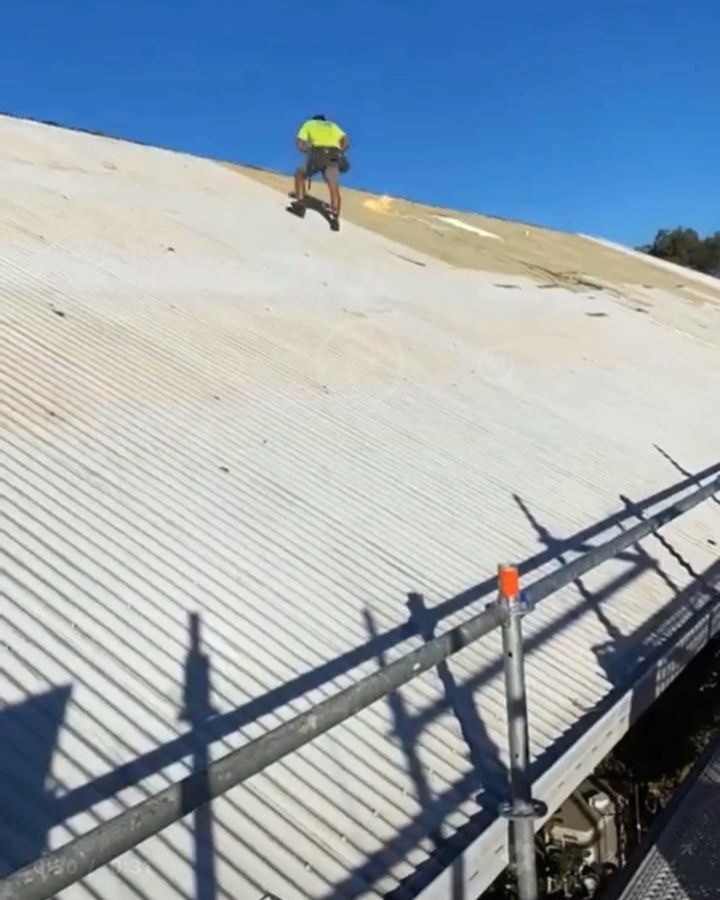 A man standing on top of a white roof