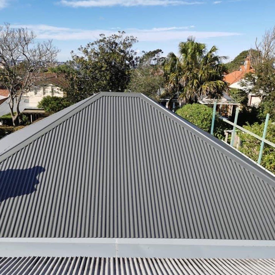 A roof with a triangle shaped roof and a blue sky in the background.