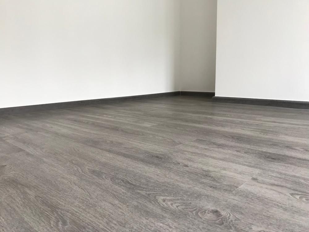 An Empty Room With A Wooden Floor And White Walls — B2B Flooring Solutions In Clarence Valley, NSW