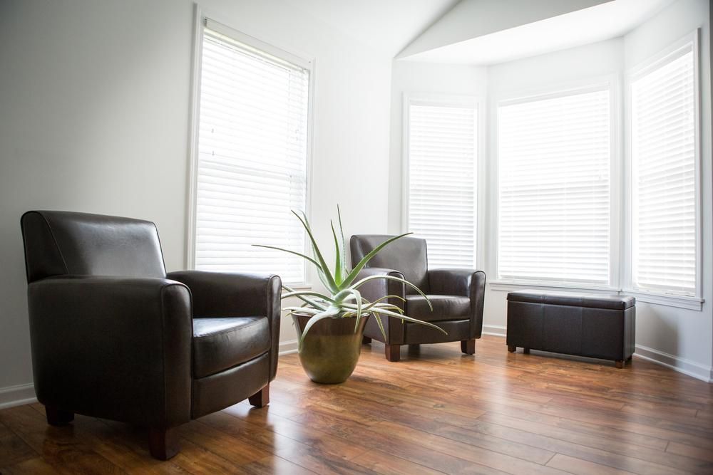 A Living Room With Two Chairs And A Potted Plant — B2B Flooring Solutions In Wauchope, NSW