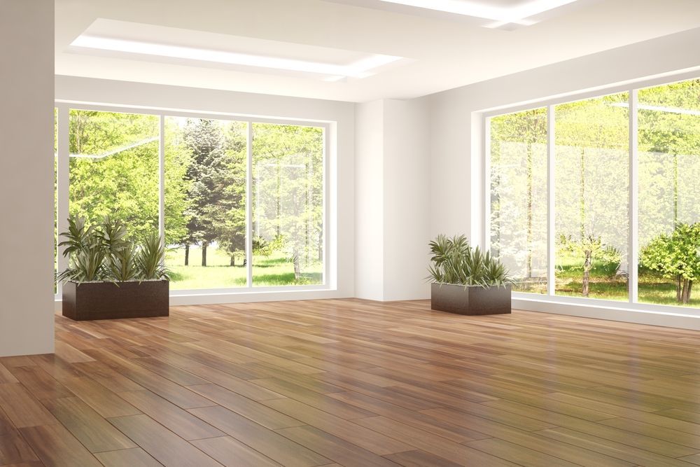 A Large Empty Room With Wooden Floors And Lots Of Windows — B2B Flooring Solutions In Yamba, NSW