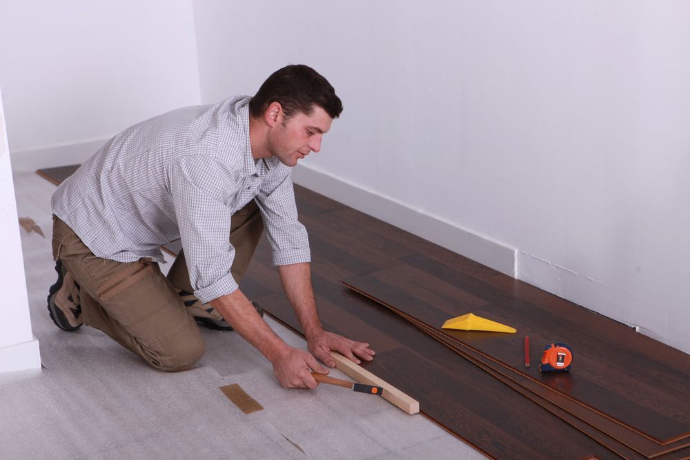 Skilled Artisan Installing Wooden Flooring — B2B Flooring Solutions In Coffs Harbour, NSW