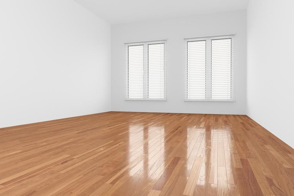 An Empty Room With A Wooden Floor And Two Windows — B2B Flooring Solutions In Wauchope, NSW