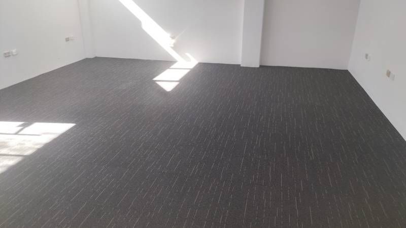 A Room With A Black Carpeted Floor And White Walls — B2B Flooring Solutions In Coffs Harbour, NSW
