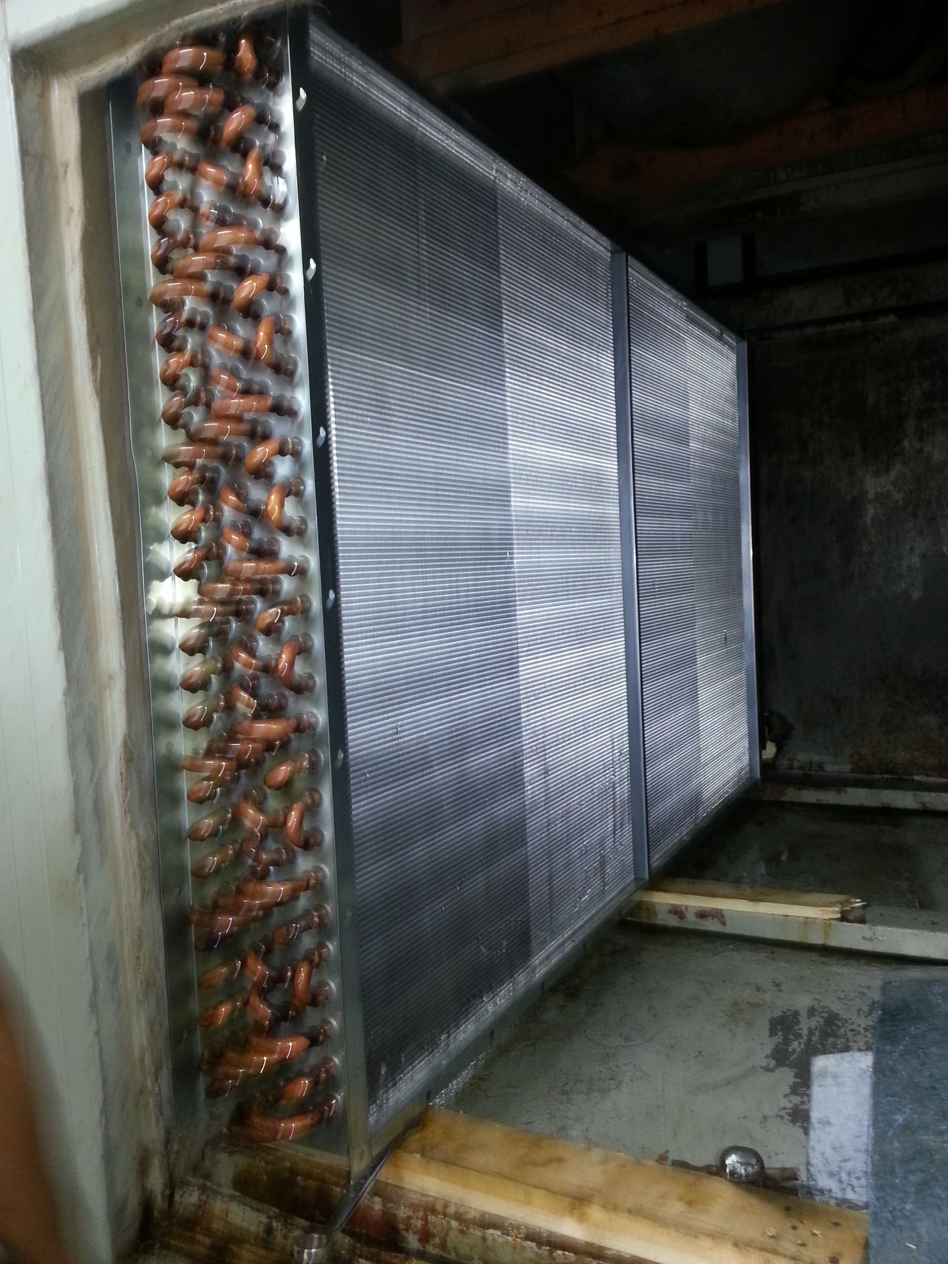 Una habitación con muchas tuberías y una escalera.