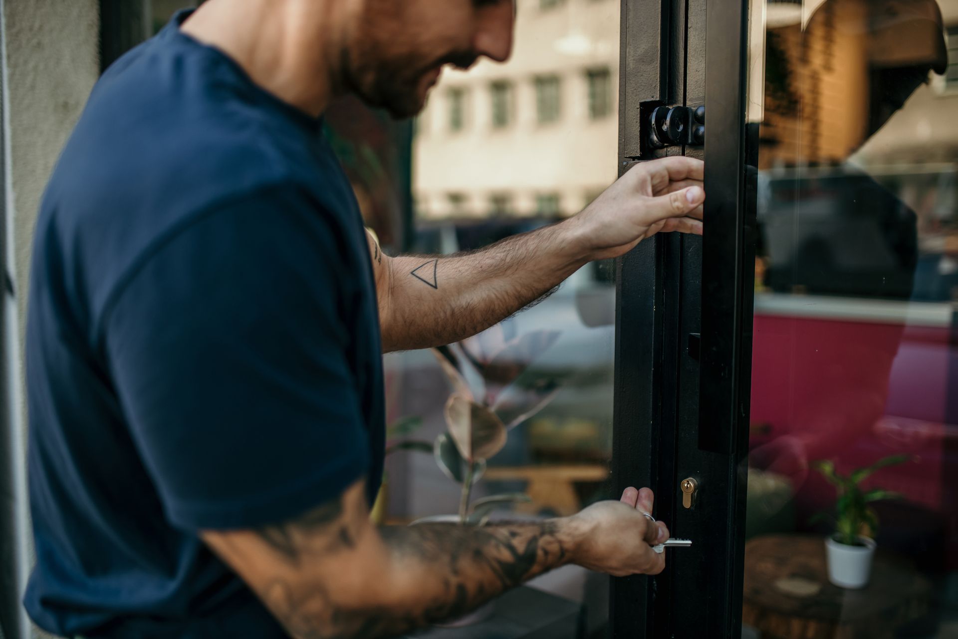 A man is opening a glass door with a key.