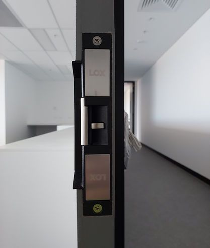 A close up of a door lock in an empty hallway.