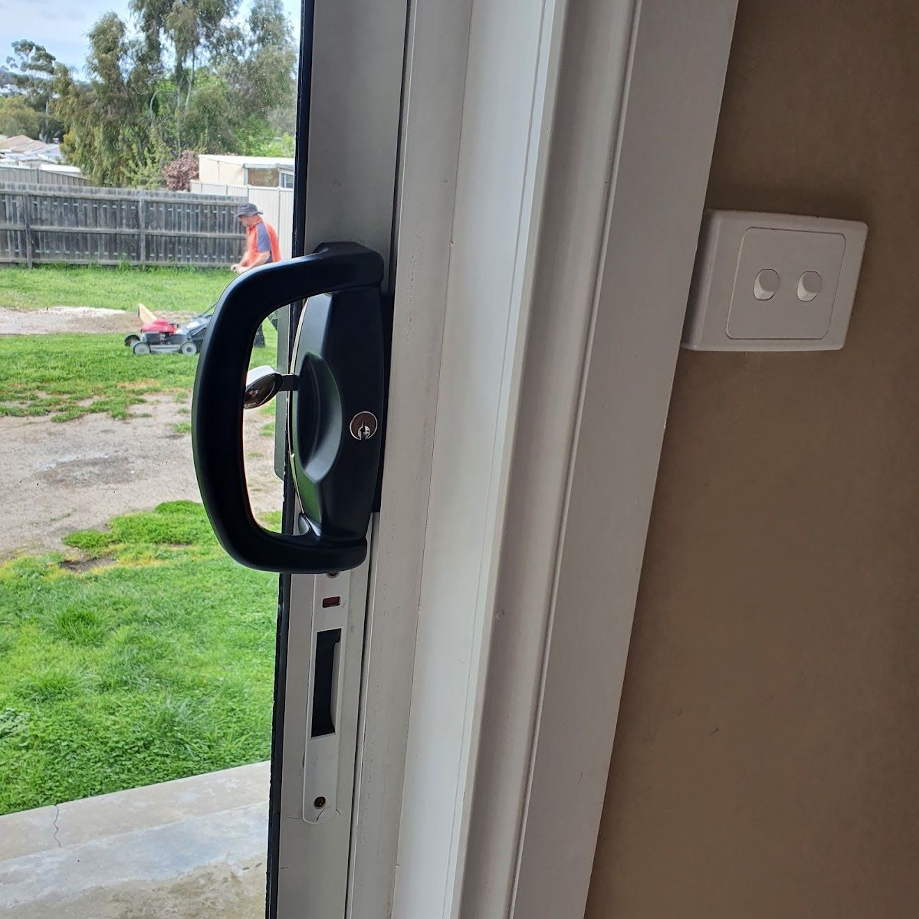A close up of a door handle on a red door.