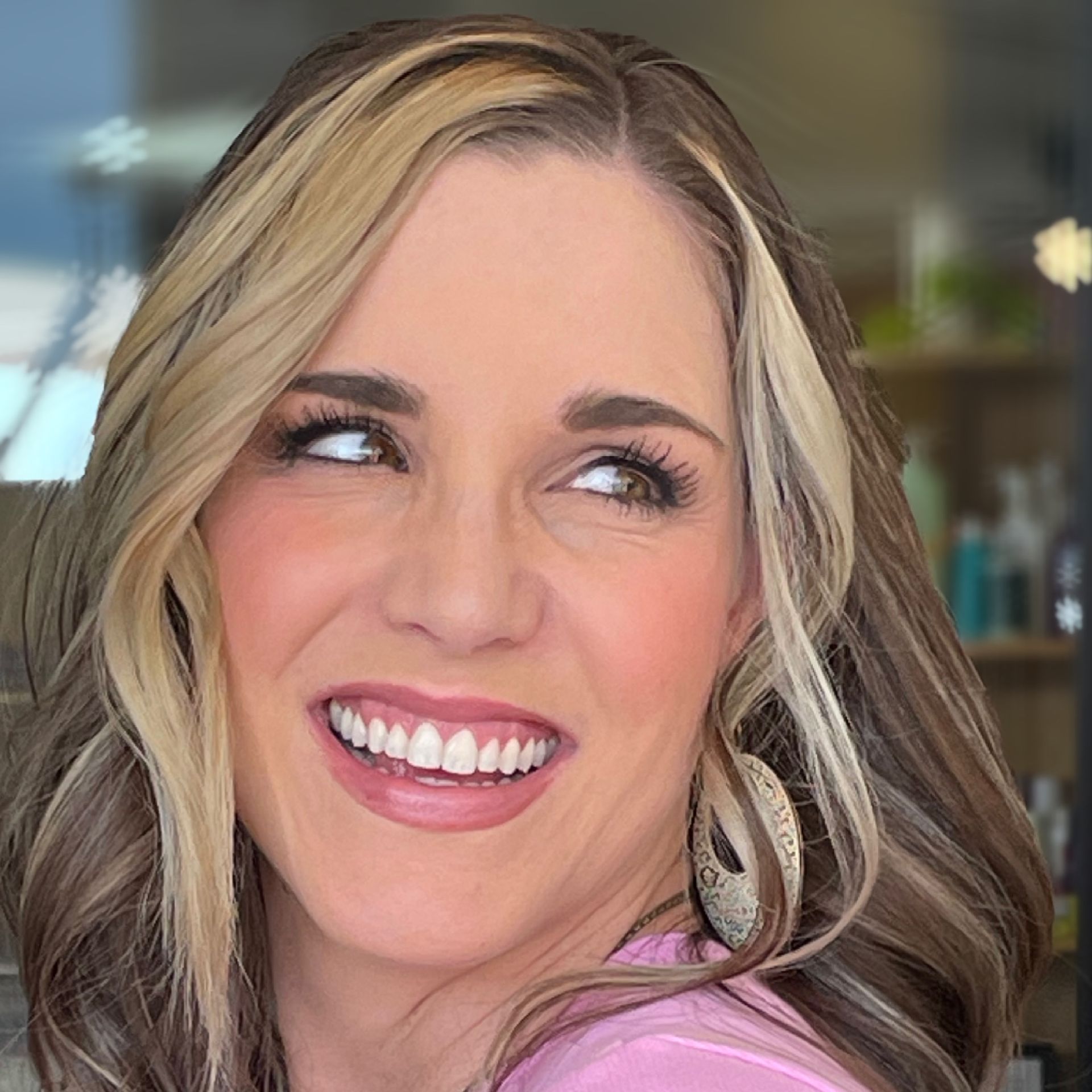 Woman with light and dark brown hair, smiling with an earring, looking upward and to the side.