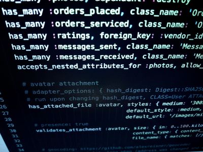 A close-up of computer code on a dark screen, displaying Ruby on Rails model associations and attachment configurations.