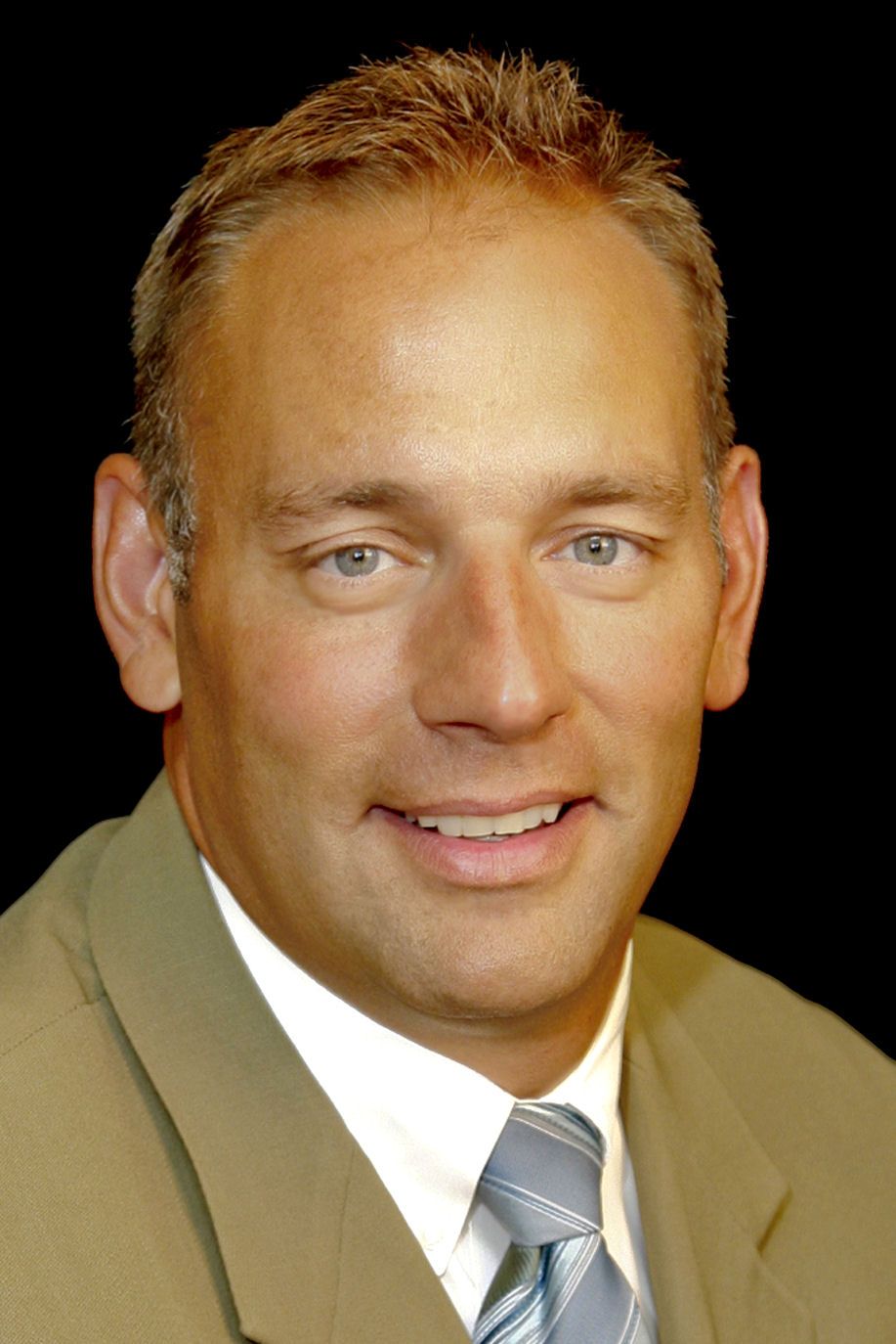 A man in a suit and tie smiles for the camera