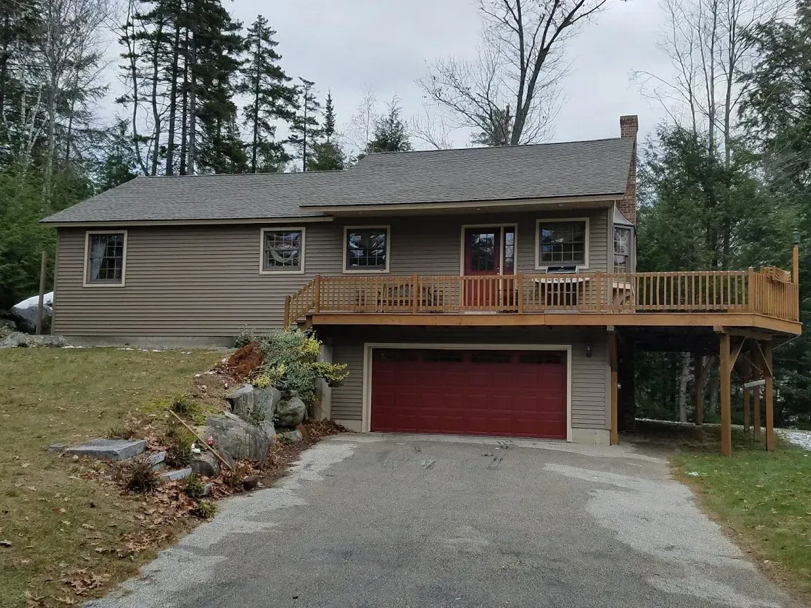 a house with a red garage door and a large deck