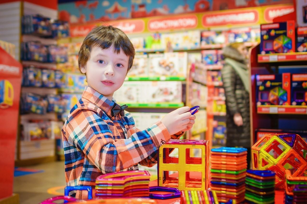 a young boy is playing with magnetic blocks in a toy store