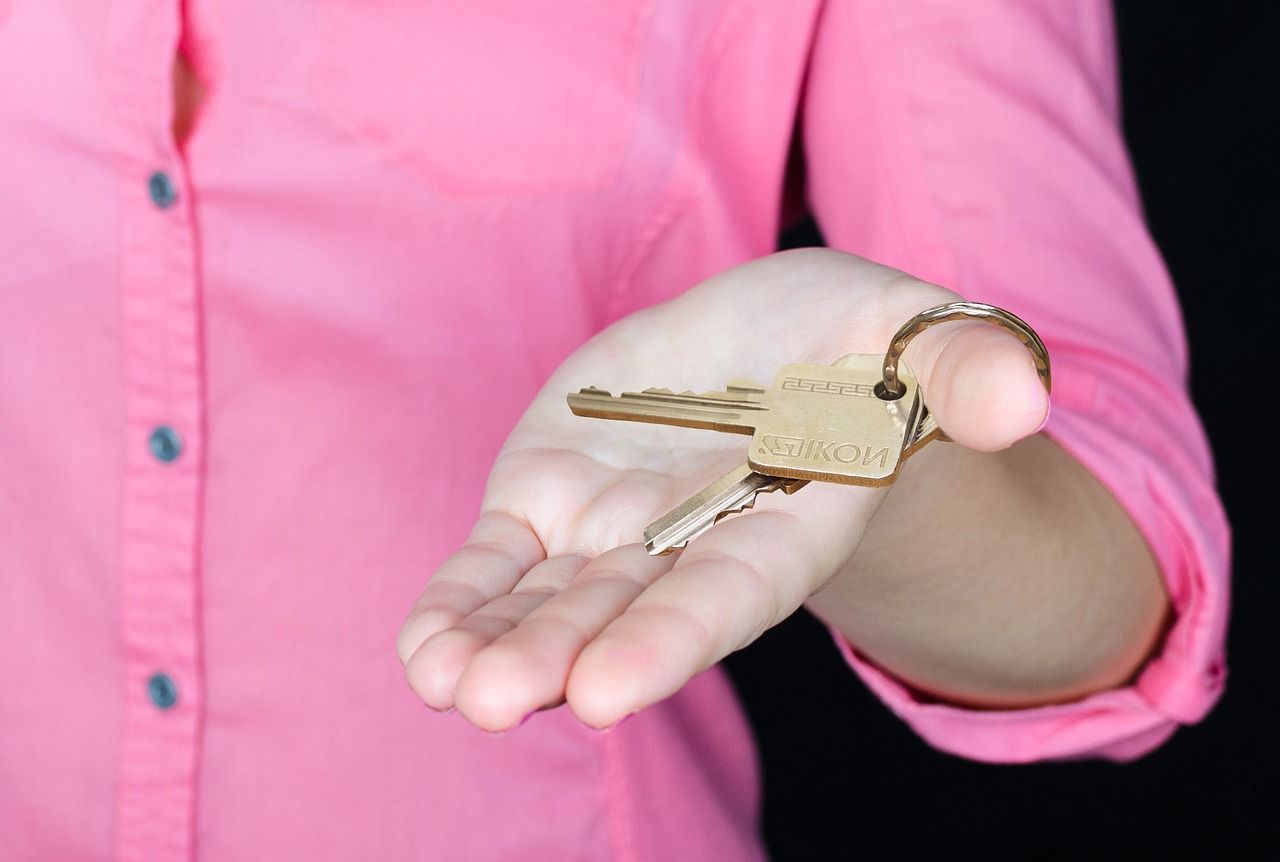 a woman in a pink shirt is holding a key in her hand