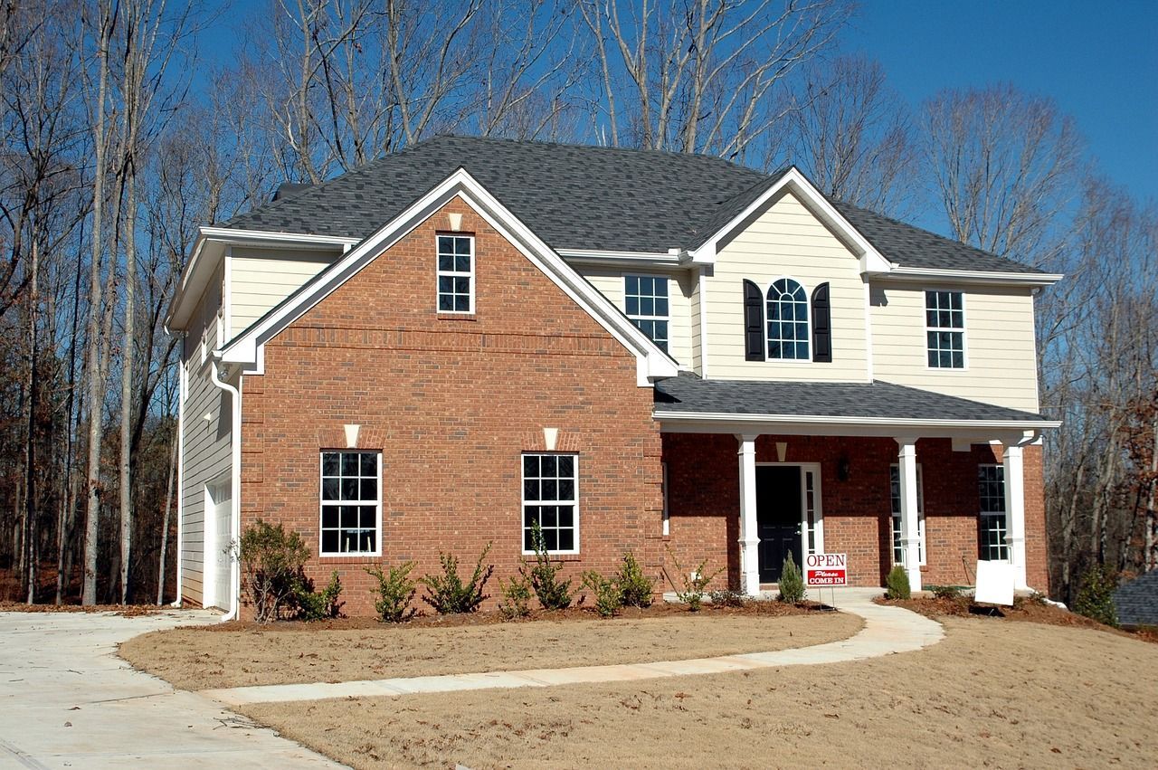 a large brick house with white trim and a gray roof