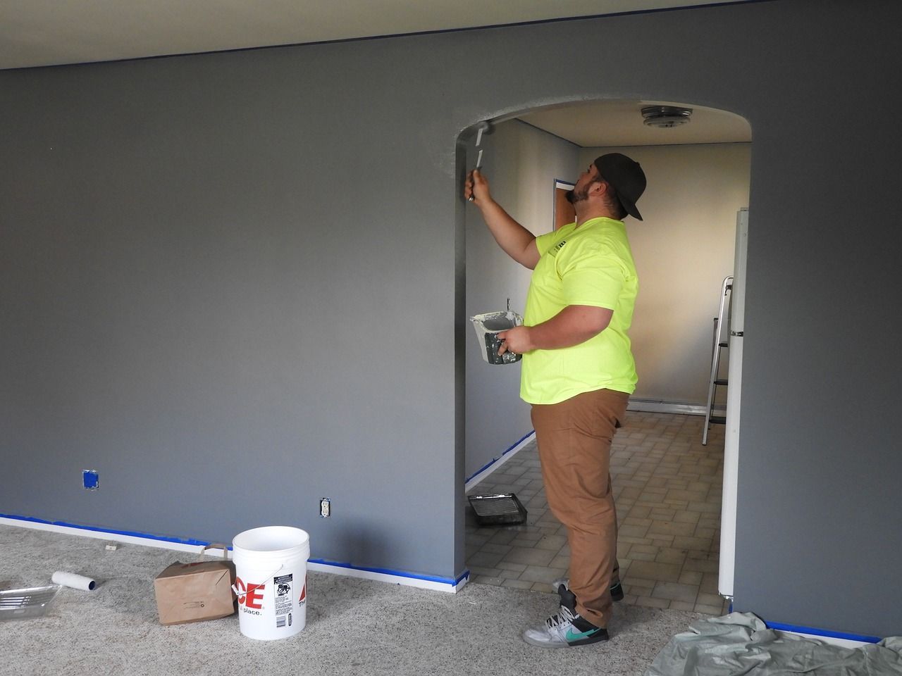 a man is painting a wall in a living room