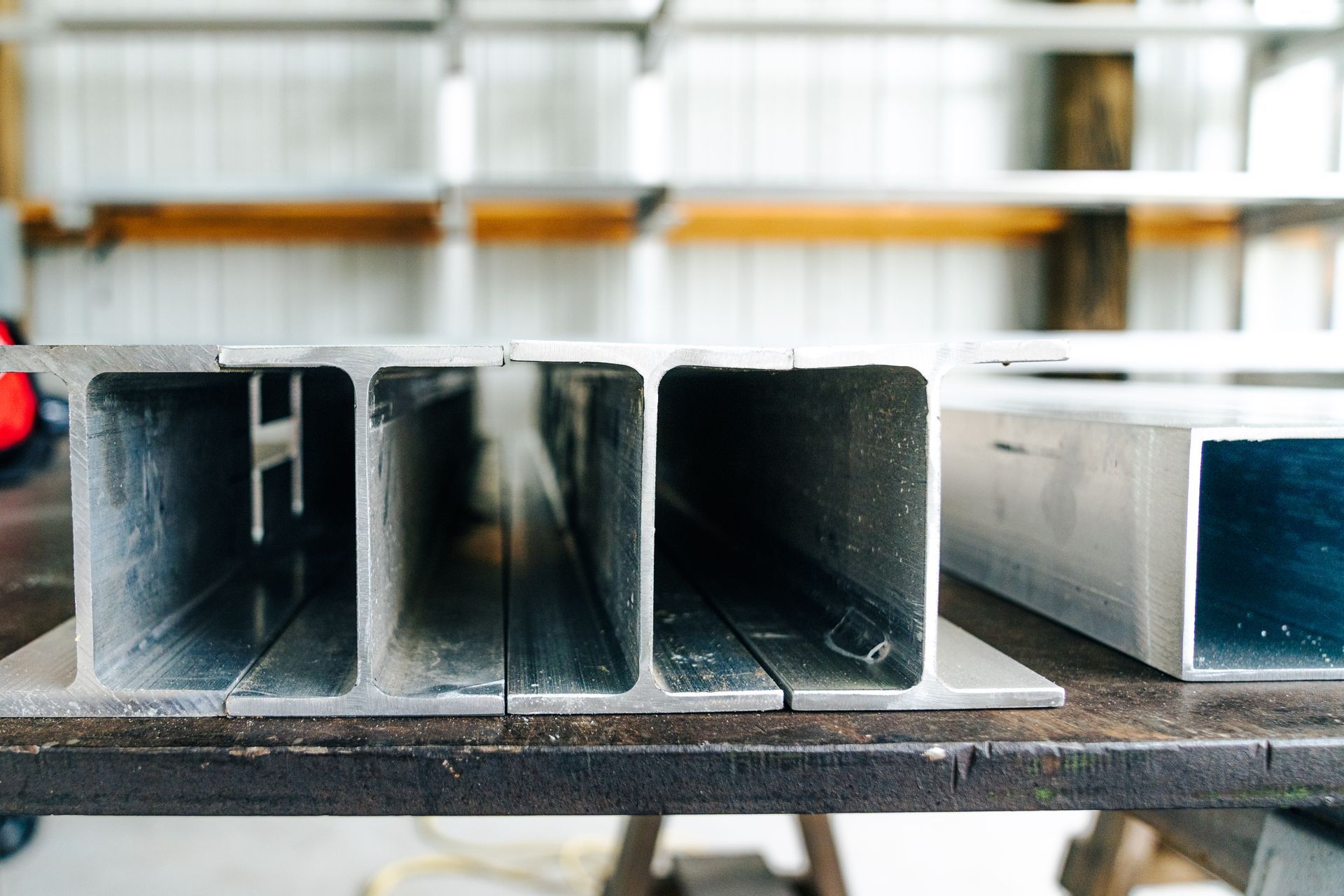 Close-up of aluminum beams with rectangular hollow sections, possibly in a workshop.