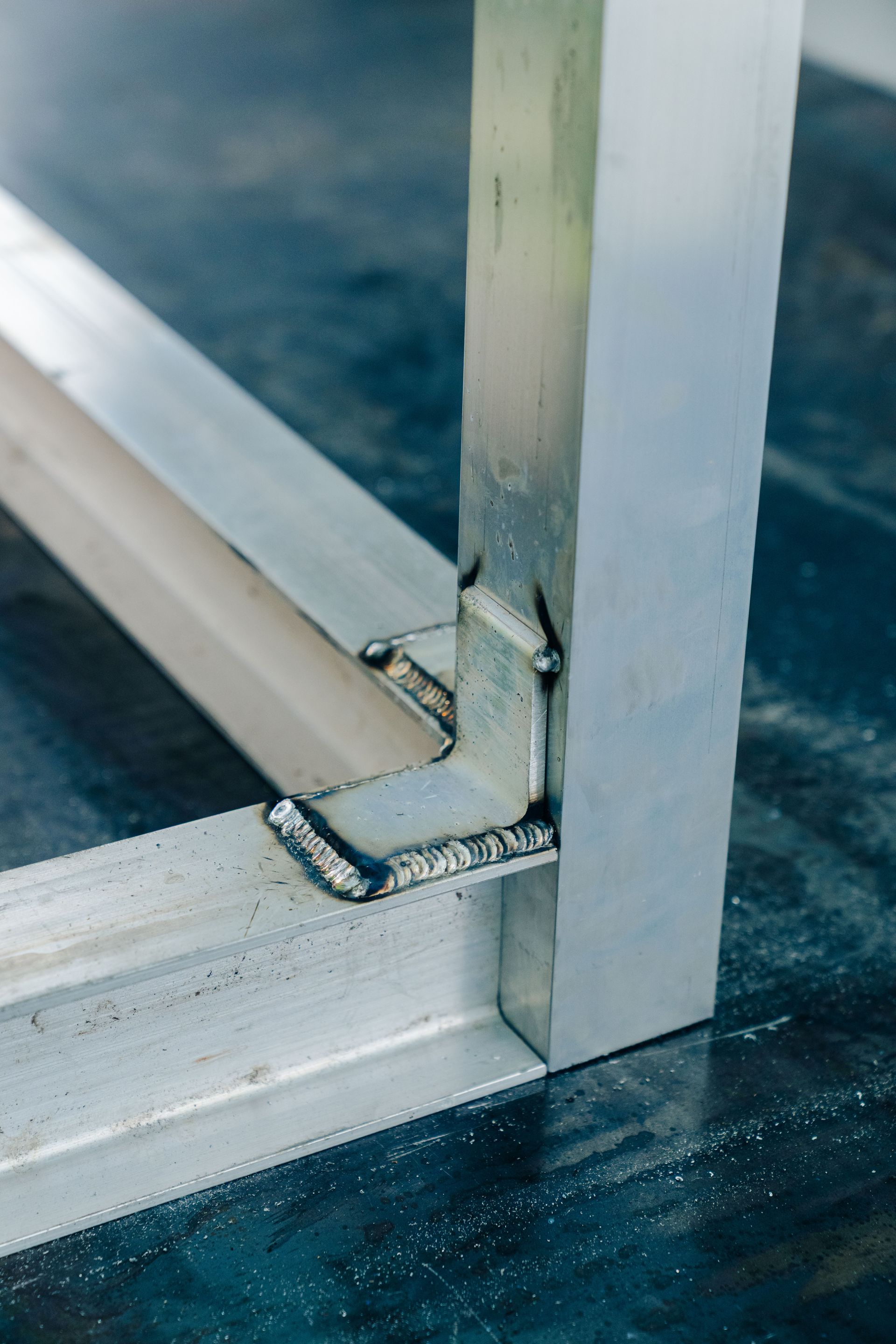 Welded aluminum frame corner joint, close-up view.