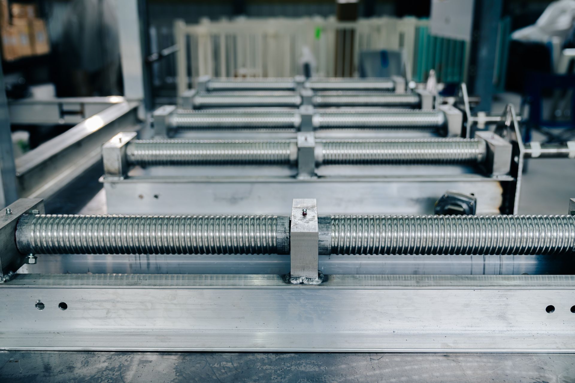 Machine with several parallel, ridged metal rollers.