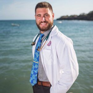 Dr. Raphael Cavalieri, DVM at Central Monmouth Animal Hospital standing by the ocean in a white coat