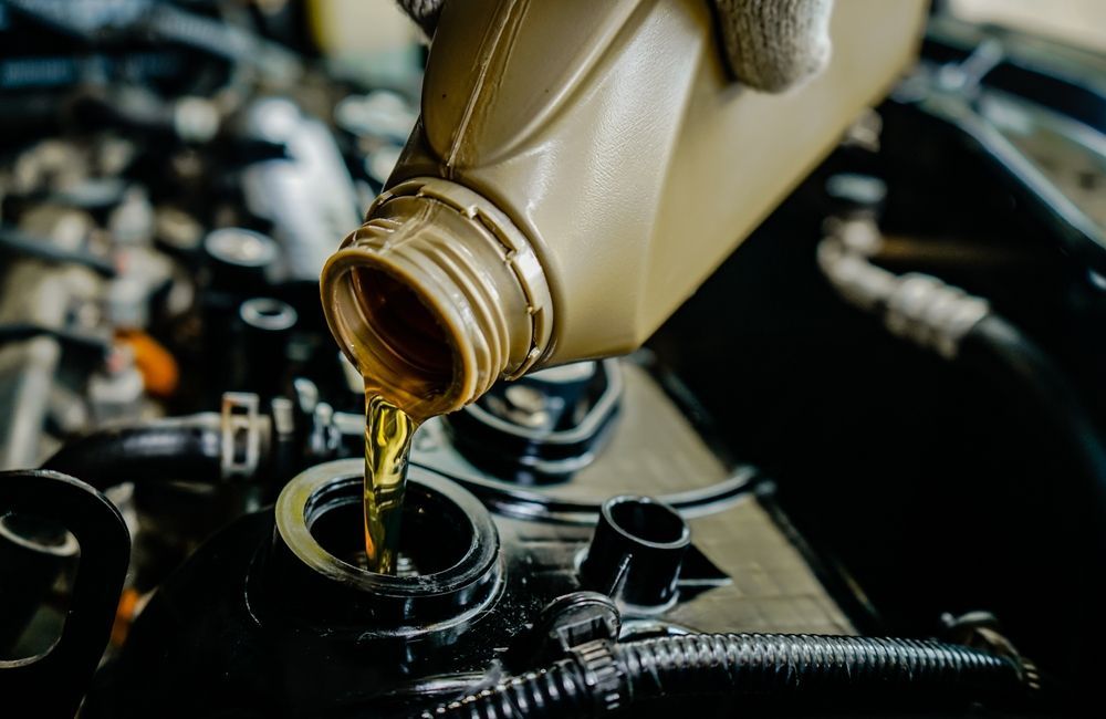 Motor oil being poured into a car engine.