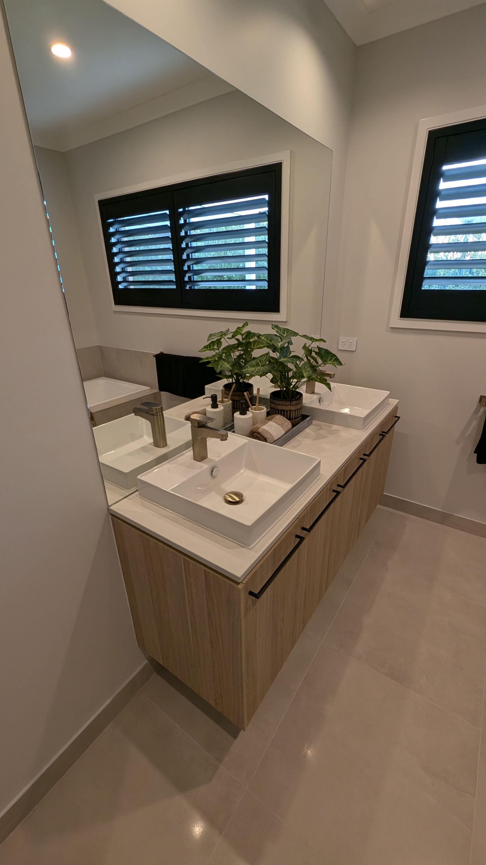A bathroom with two sinks and a large mirror.