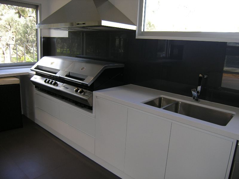 A kitchen with a grill and a sink in it