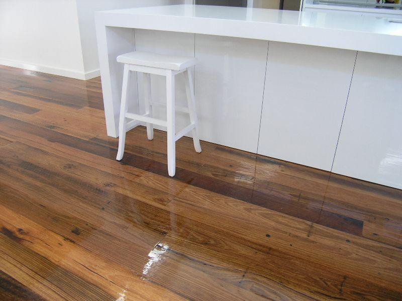 A white stool is sitting on a wooden floor in a kitchen.