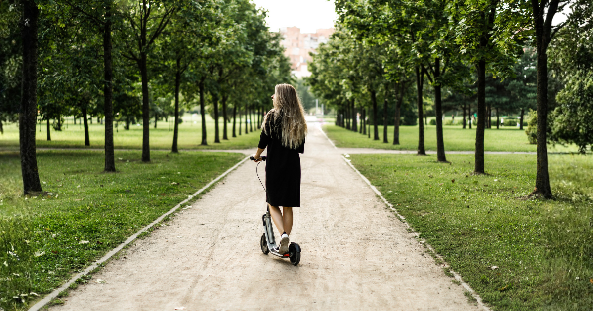 Mulher andando de patinete em um parque de Maringá