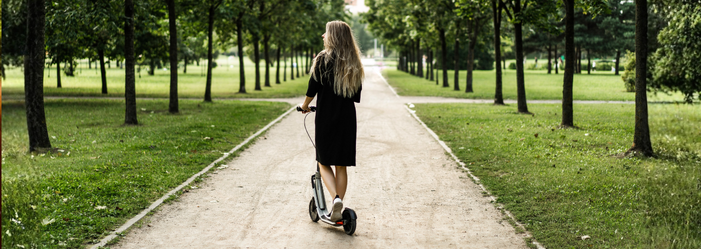 Mulher passeando de patinete em um parque de Maringá