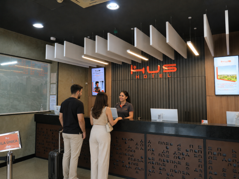 Recepcionista do Hus Hotel recebendo os hospedes
