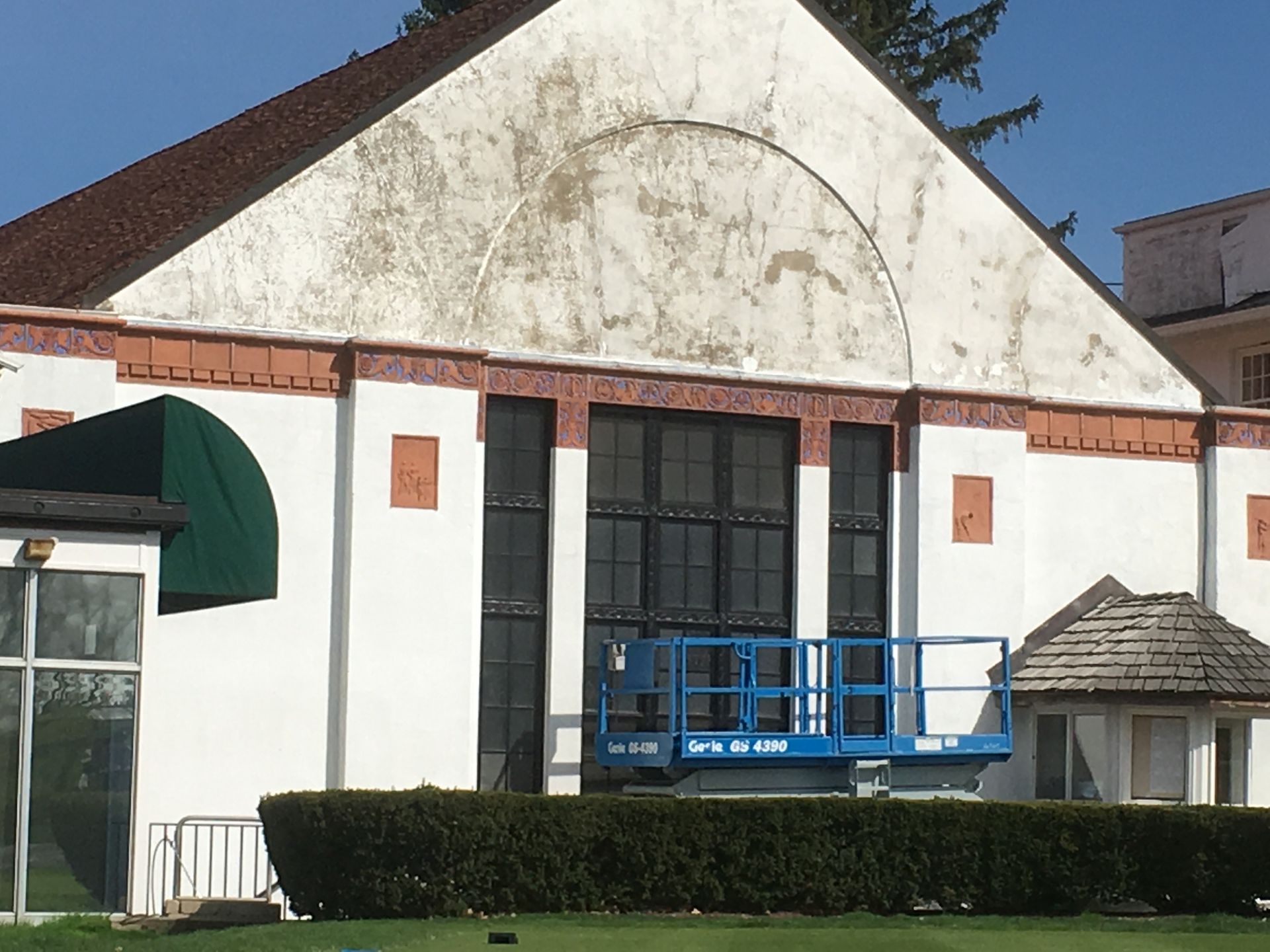 A large white building with a blue lift in front of it