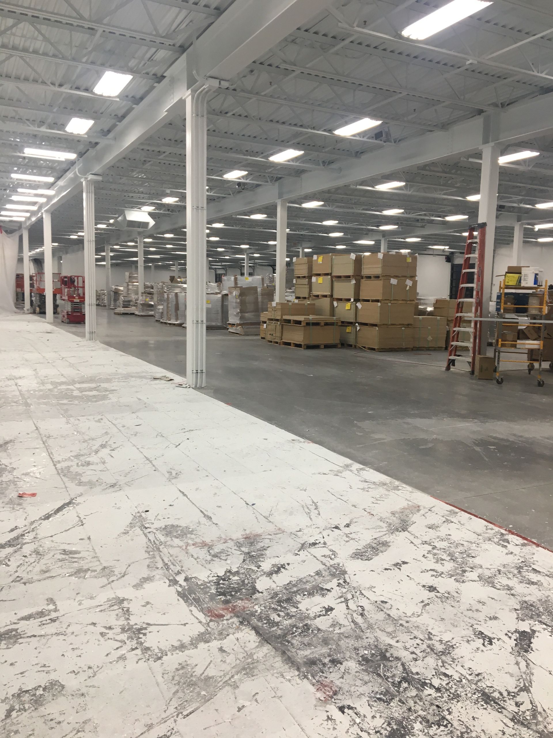 A large warehouse with a lot of boxes on the floor