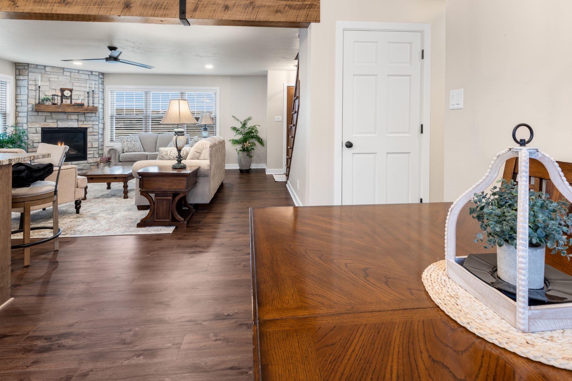 A living room with hardwood floors , a couch , a table and a fireplace.