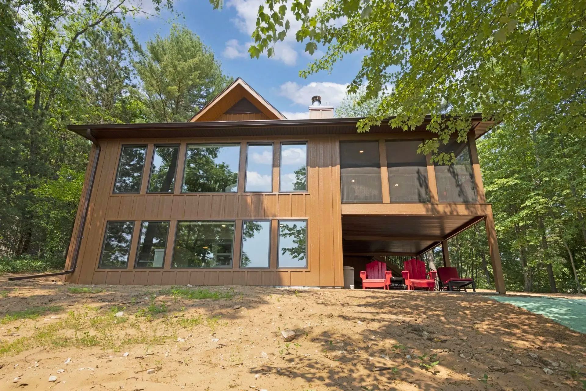 A large house with a lot of windows is surrounded by trees.