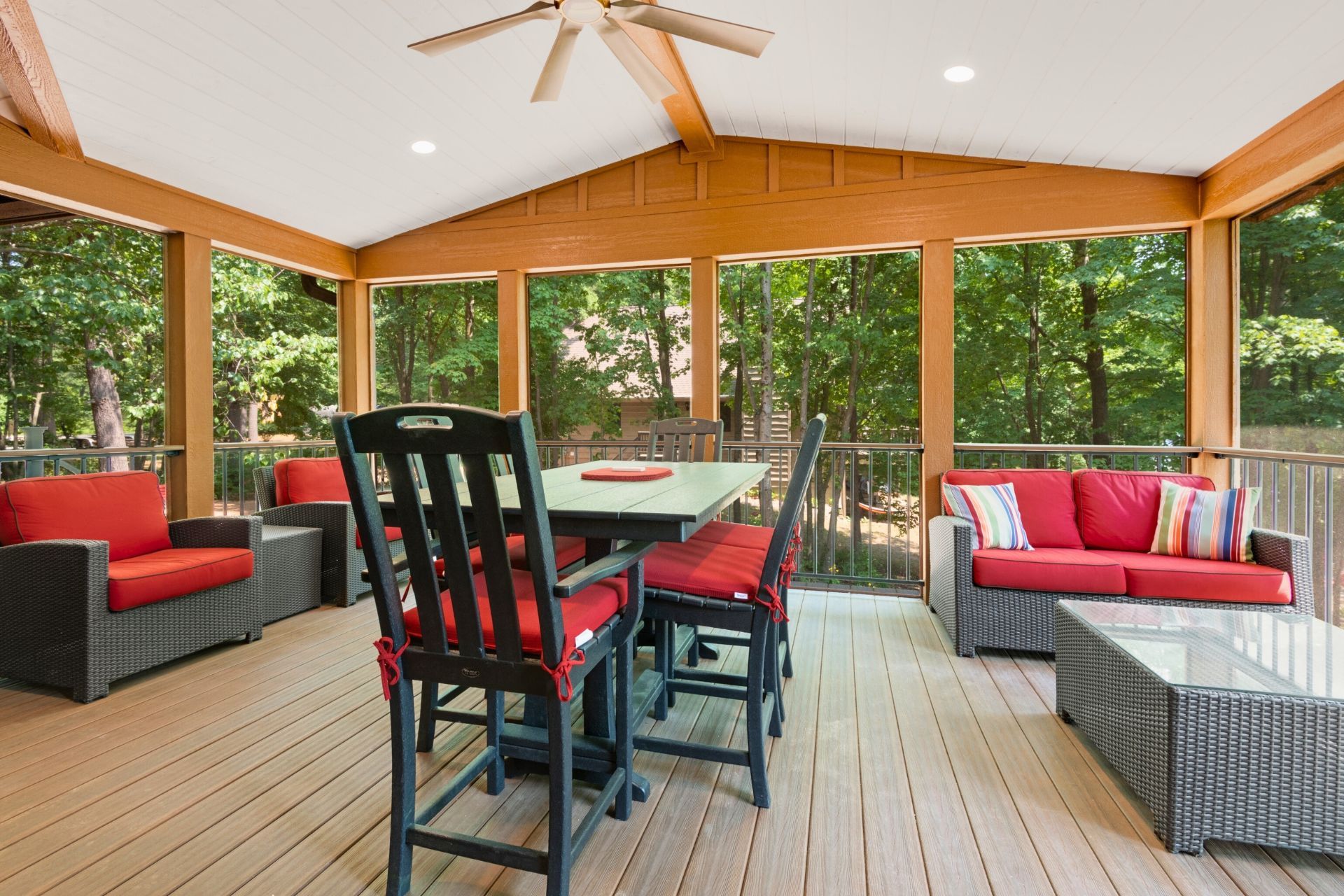 A screened in porch with a table , chairs , and a couch.