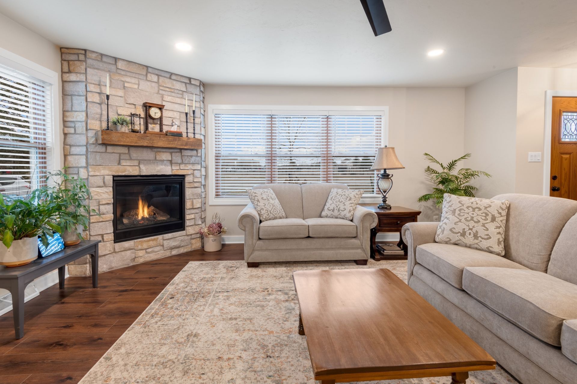 A living room with a couch , chair , coffee table and fireplace.