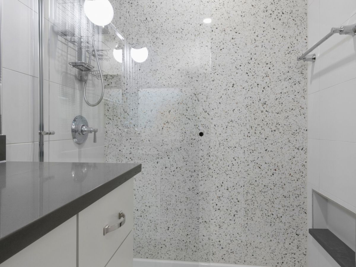 A bathroom with a walk in shower and a sink.