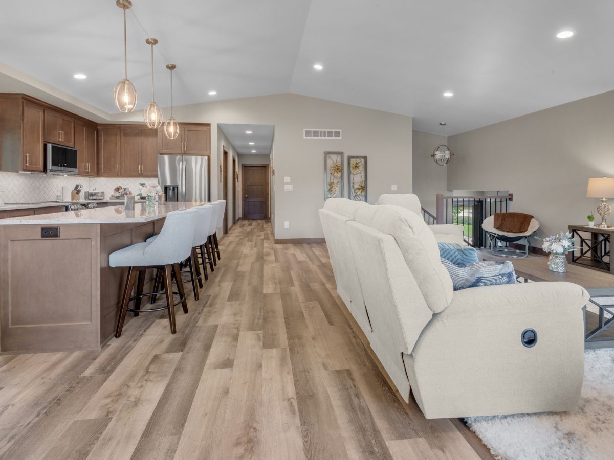 A living room with a couch and a kitchen in the background.