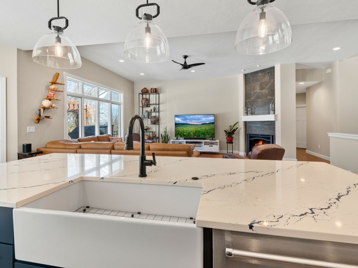 A kitchen with a sink and a stainless steel refrigerator.