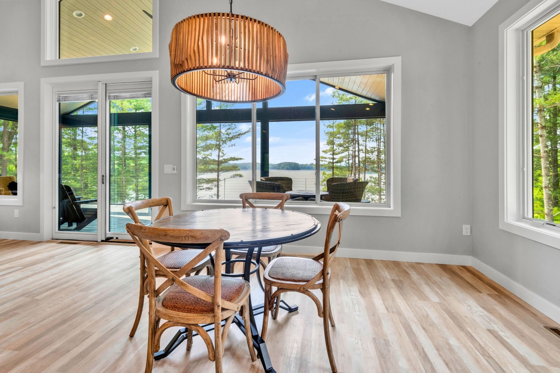 A dining room with a table and chairs and a view of a lake.