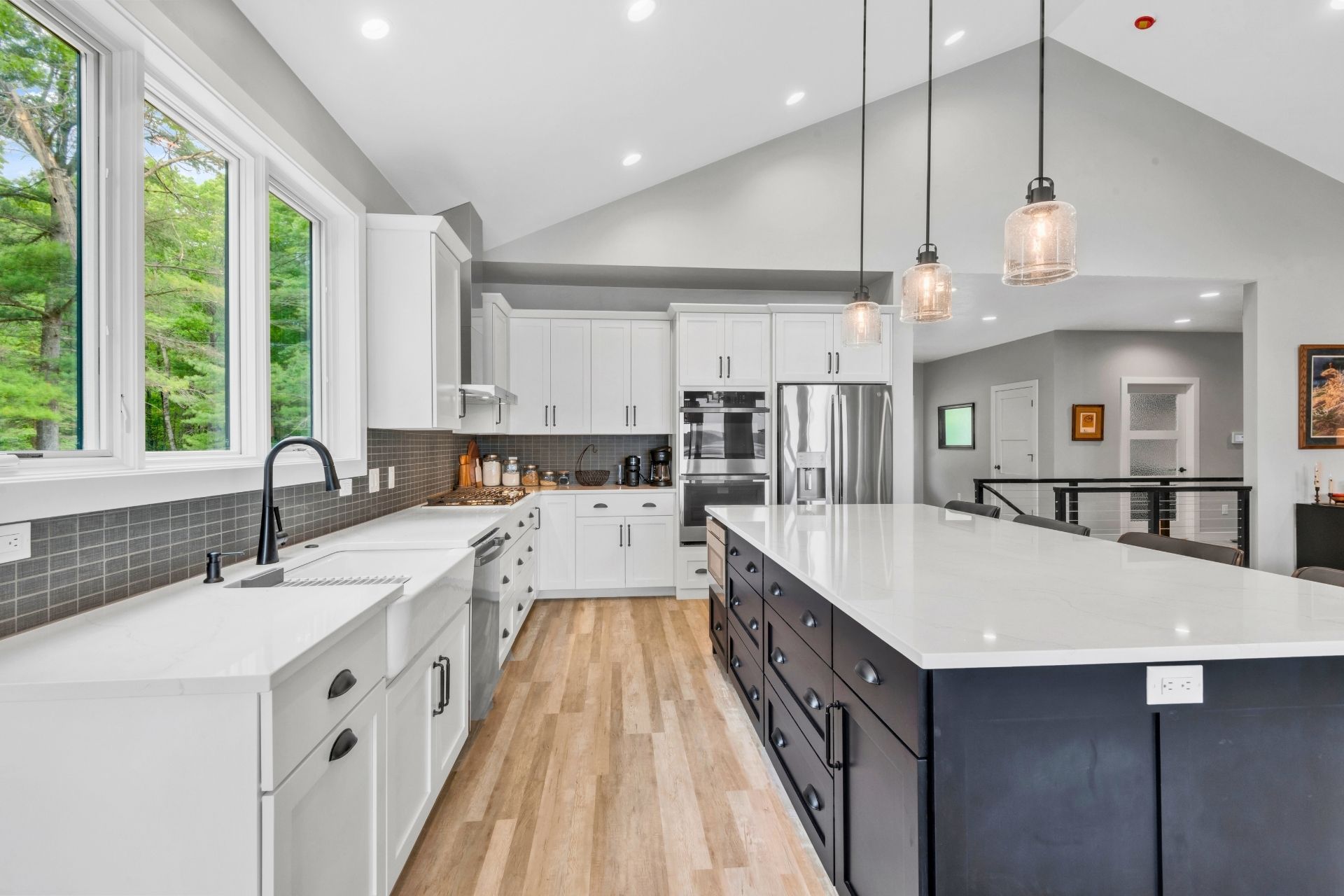 A kitchen with a large island in the middle and white cabinets.