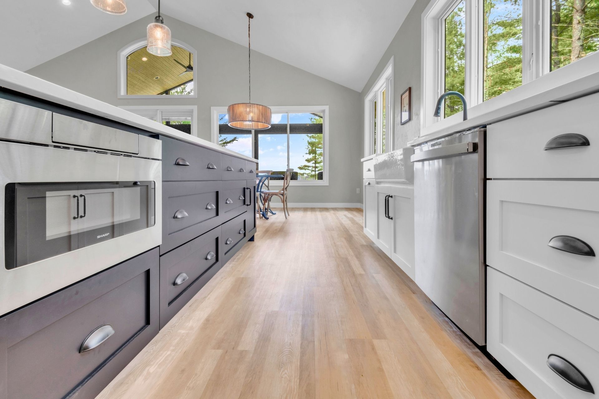 A kitchen with black and white cabinets and stainless steel appliances.