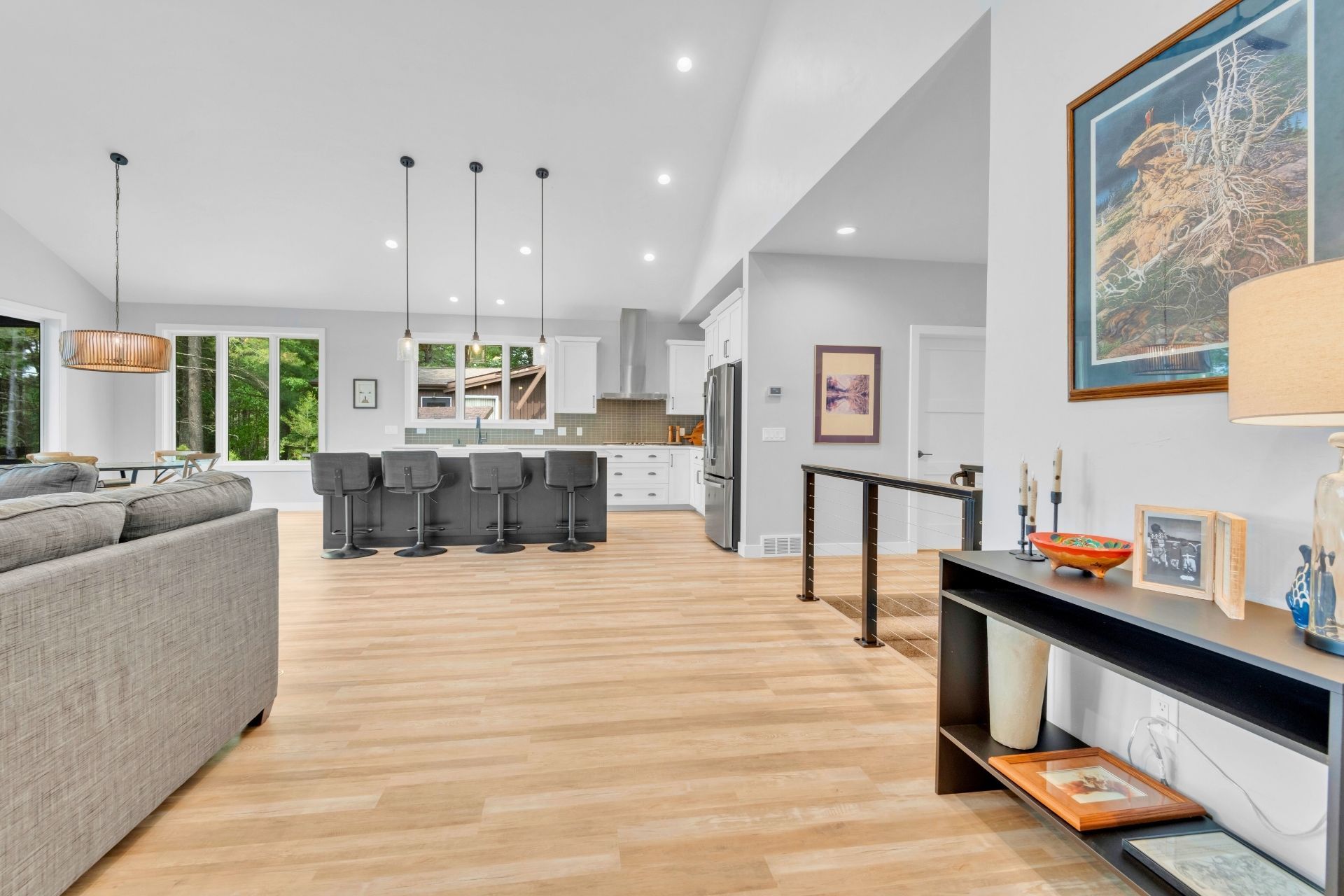 A living room with hardwood floors , a couch , a table and a picture on the wall.