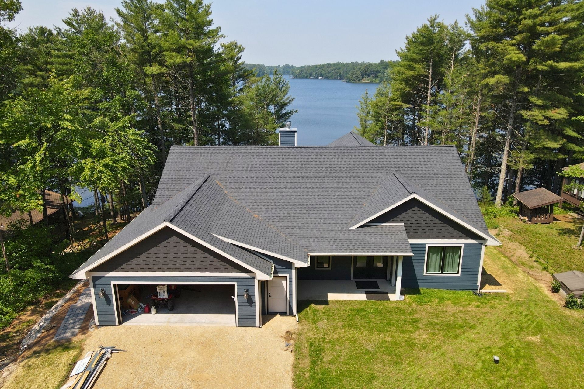 An aerial view of a house with a lake in the background