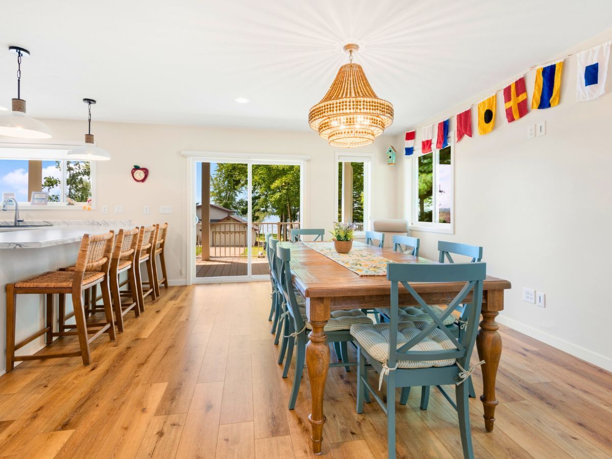 A dining room with a long wooden table and chairs.