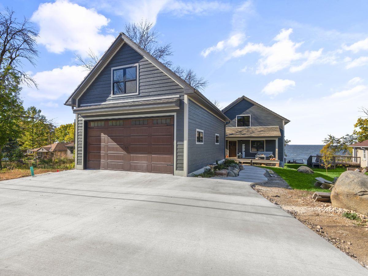 A house with a garage and a driveway in front of it.